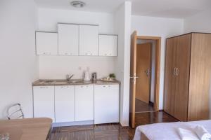 a kitchen with white cabinets and a sink in a room at Apartmani Sweet Dream in Višegrad