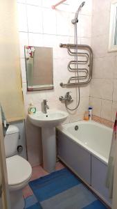 a bathroom with a sink and a tub and a toilet at Apartment - Generala Petrova Street in Odesa +6 photos