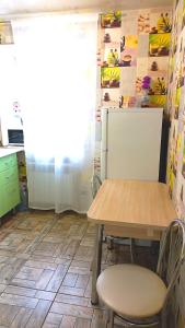 a kitchen with a table and chairs and a refrigerator at Apartment - Generala Petrova Street in Odesa