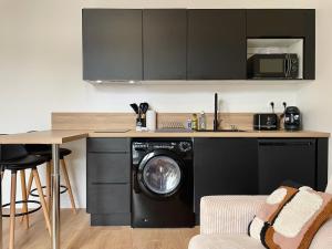 a kitchen with a washing machine under a counter at Cocon zen du clocher - SOnights in Château-du-Loir