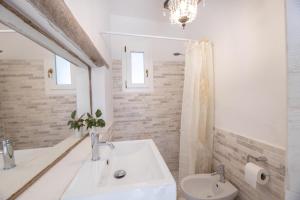 La salle de bains blanche est pourvue d'un lavabo et de toilettes. dans l'établissement Villa Ametista, à Taviano