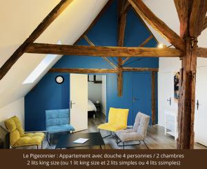 una sala de estar con paredes azules y vigas de madera. en Le Pigeonnier centre historique Auxerre en Auxerre