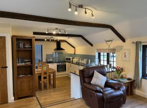 a living room with a couch and a kitchen at Maple & Beech Barns in Truro