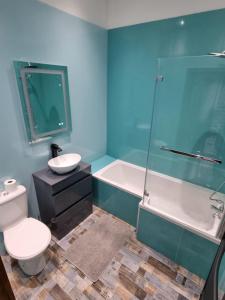 a bathroom with a toilet and a tub and a sink at New with Free Offstreet Parking The Old Drill Hall 3 in Ryde