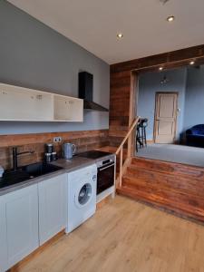 a kitchen with white cabinets and a washer and dryer at New with Free Offstreet Parking The Old Drill Hall 3 in Ryde