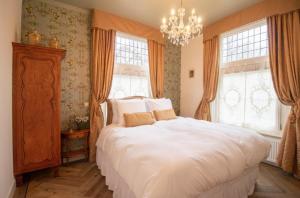 a bedroom with a large white bed and windows at Hotellerie Het Wapen Van Athlone in De Steeg