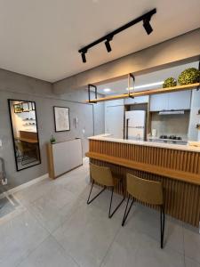 Apartamento/Studio Novo Hamburgo في نوفو هامبورغو: مطبخ مع كونتر وكراسي في غرفة