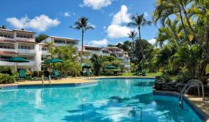 a swimming pool at a resort with palm trees at Sea View - Glitter Bay in Saint James