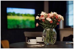 a vase filled with pink and white flowers on a table at Apartament przy Synagodze in Zamość
