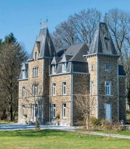 a large brick building with a large roof at Château de Porcheresse in Daverdisse