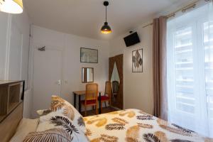 a bedroom with a bed and a table and a window at Ideal Hotel in Paris