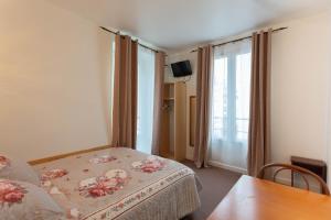 1 dormitorio con cama, mesa y ventana en Ideal Hotel en París