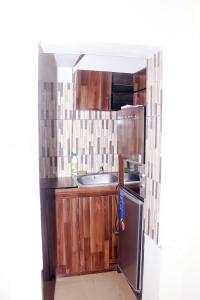 een keuken met houten kasten en een roestvrijstalen koelkast bij Smilley's Place Szilvie in Lagos