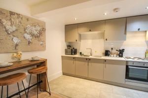 a kitchen with white cabinets and a map on the wall at Spacious 1 Bed Apartment 1 Minute Walk from Square in Nottingham