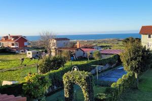a view of a garden with a fence and a house at Villa de Cueto in Santander