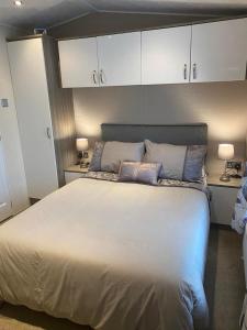 a bedroom with a large white bed with two pillows at 2 Bed Lodge Style Caravan with Hot Tub & Private Garden in Patrington
