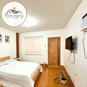 Кровать или кровати в номере Malunggay Apartments