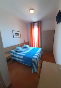 un letto blu in una stanza con finestra di Activ Hotel Salsedine a Rimini