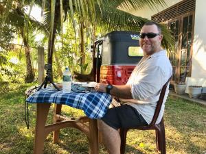 a man sitting at a table with a table cloth at Lucky's Homestay in Maho