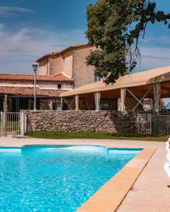 a blue swimming pool in front of a house at Mas De Baumes in Ferrières-les-Verreries