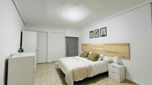 Dormitorio blanco con cama y cabecero de madera en Valencia Private Rooms in Shared Apartment, en Valencia