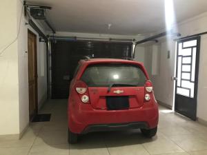 a small red car parked in a garage at Albano: Habitación completa acústica in Chosica