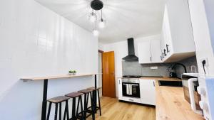 a kitchen with white cabinets and a counter with stools at Valencia Private Rooms in Shared Apartment in Valencia