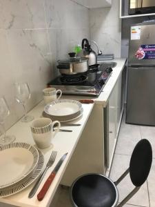 a kitchen with plates and utensils on a counter at Albano: Habitación completa acústica in Chosica