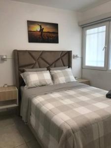ein Schlafzimmer mit einem großen Bett mit einer karierten Decke in der Unterkunft Albano: Habitación completa acústica in Lurigancho-Chosica