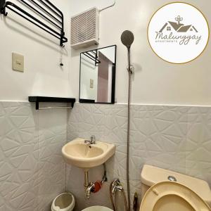uma pequena casa de banho com lavatório e WC em Malunggay Apartments em Mariveles