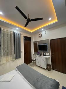 Shivraj Inn في فاراناسي: غرفة نوم بسرير ومروحة سقف
