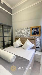 a bedroom with a large bed with white pillows at City Hotel Turkistan in Türkistan
