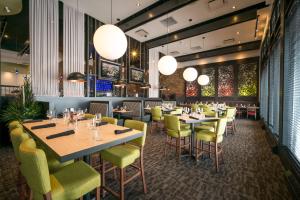 um restaurante com mesas, cadeiras e luzes em Acclaim Hotel by CLIQUE em Calgary