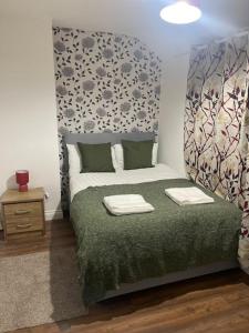 1 dormitorio con 1 cama con edredón verde en Tms 3bdr Tilbury - Free Parking, en Tilbury