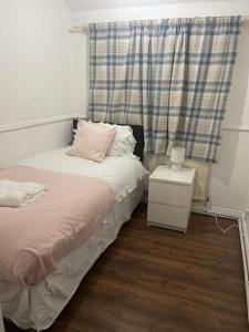 a small bedroom with a bed and a window at Tms 3bdr Tilbury - Free Parking in Tilbury