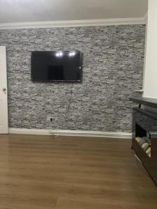 a living room with a tv on a stone wall at Tms 3bdr Tilbury - Free Parking in Tilbury