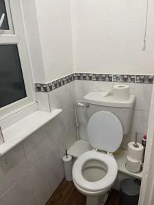 a small bathroom with a white toilet and a window at Tms 3bdr Tilbury - Free Parking in Tilbury