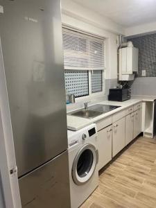 a kitchen with a washing machine and a sink at Tms 3bdr Tilbury - Free Parking in Tilbury