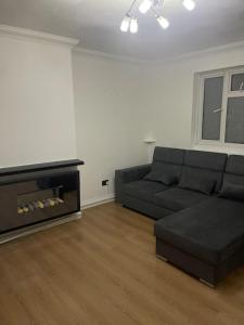 a living room with a black couch and a television at Tms 3bdr Tilbury - Free Parking in Tilbury