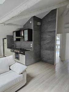 sala de estar con sofá y cocina en Casa Laura - Riva del Garda, en Riva del Garda