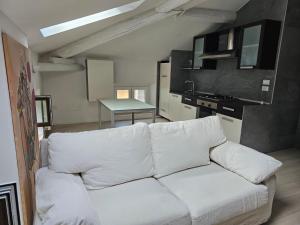 sala de estar con sofá blanco y cocina en Casa Laura - Riva del Garda, en Riva del Garda