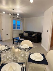 a dining room with a table with plates and wine glasses at Centrally Located Flat in London with Free Parking in Edgware