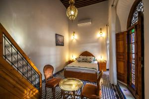 a bedroom with a bed and a table and chairs at Riad Jamal in Fez