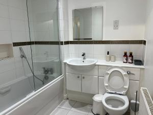 y baño con aseo, lavabo y ducha. en Centrally Located Flat in London with Free Parking en Edgware