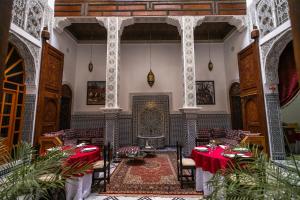 a dining room with red tables and a fireplace at Riad Jamal in Fez