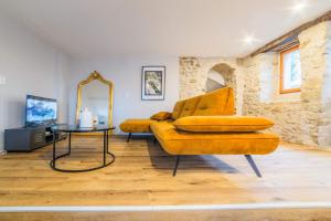 uma sala de estar com um sofá amarelo e um espelho em BOYER 3 - Maison Terrasson - 3 chambres em Terrasson