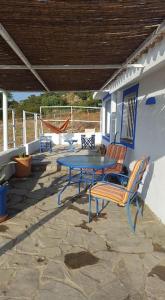 um pátio com uma mesa azul e cadeiras numa casa em CASITA LINDA em Facinas