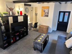 ein Wohnzimmer mit einem Sofa, einem TV und einem Tisch in der Unterkunft Comfort Zone in Colchester