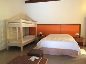 a bedroom with a bed and a bunk bed at Pousada Canto da Enseada in Nazaré Paulista