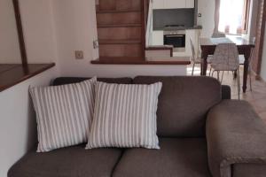 a couch with two pillows in a living room at La Casetta in Porto Santo Stefano